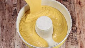 colocando a massa do bolo de banana com cenoura para assar